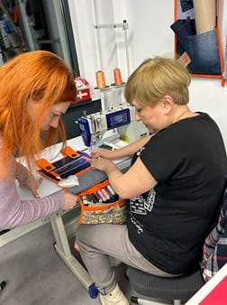 A seamstress trainee learning on an industrial sewing machine